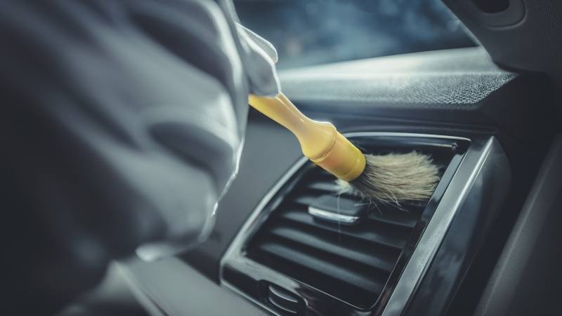 brushing air vents in a car