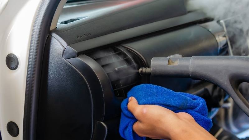 using steam cleaner to clean cracks and crevices in car