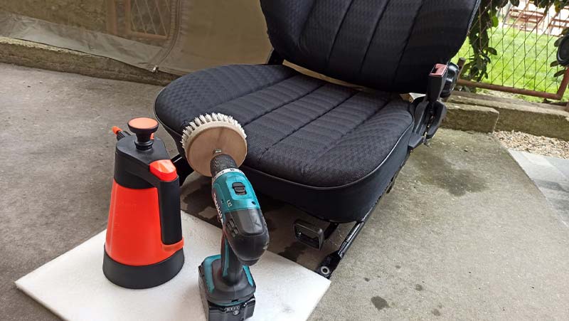 using carpet cleaning solution and drill brush to clean car seats