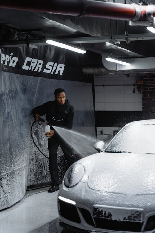 car detailer washing a porsche